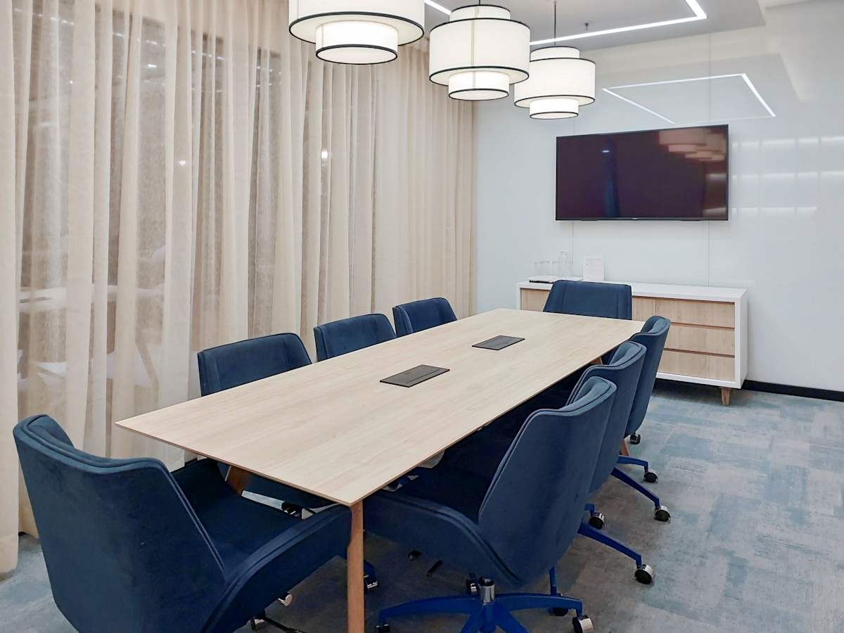 Modern conference room with cozy seating, elegant lighting, and advanced AV setup in मुंबई.