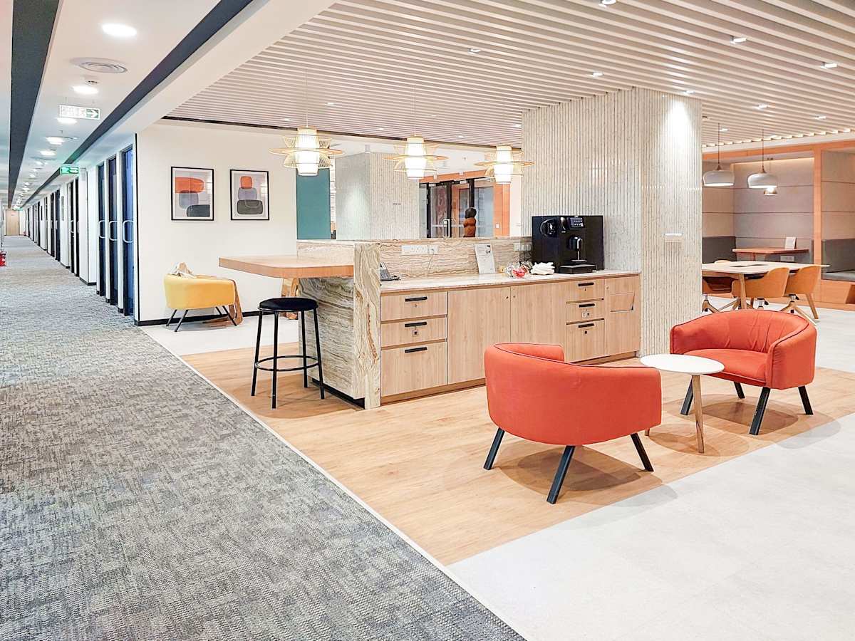 Modern coworking space in Mumbai with cozy seating, sleek decor, and a convenient coffee bar.