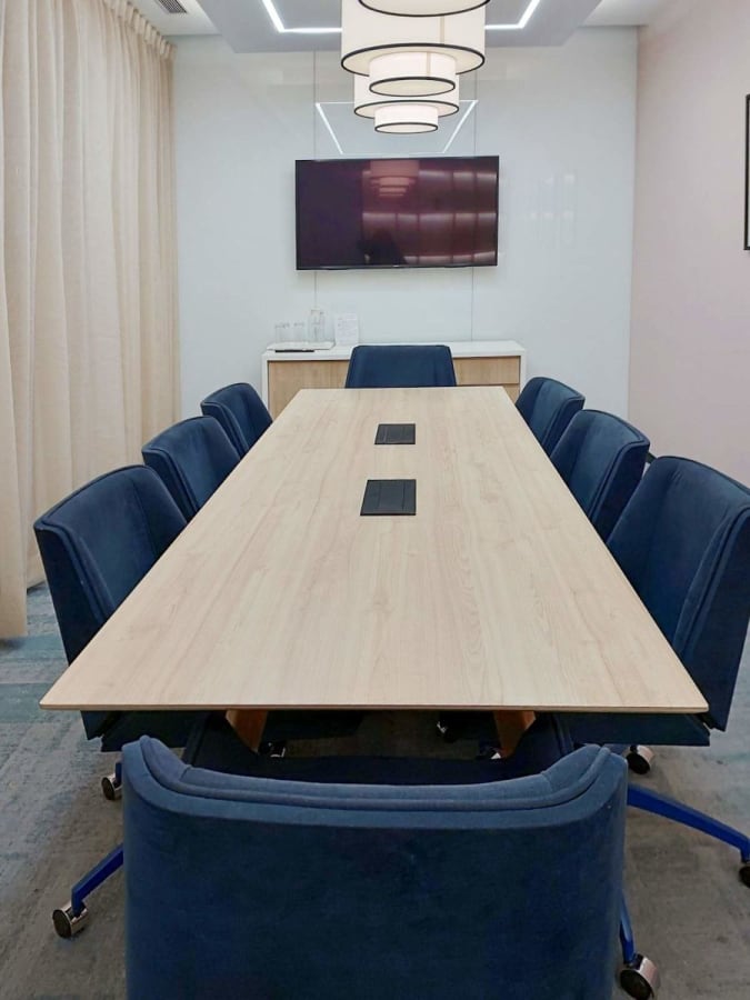 Modern conference room with plush seating and advanced AV setup, ideal for dynamic meetings.