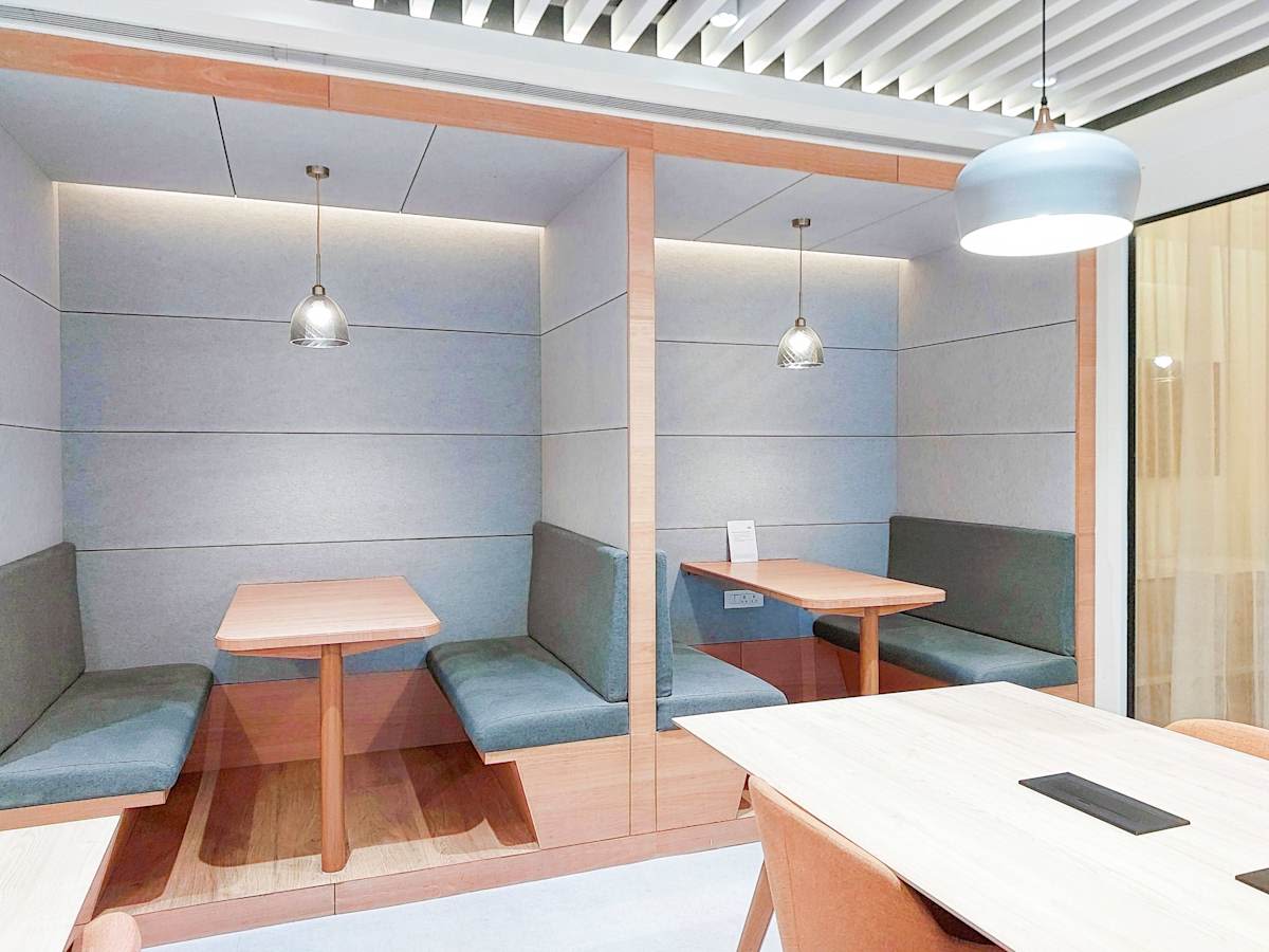 Modern coworking booths offer privacy and comfort in a stylish Mumbai office space.