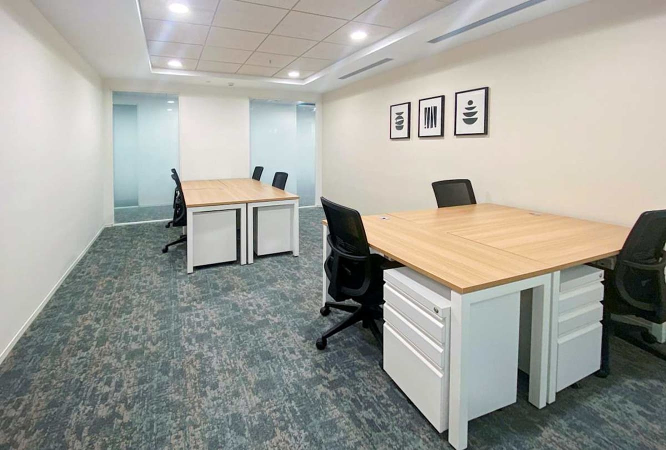 Modern coworking area with spacious desks, ergonomic chairs, and ample natural light.