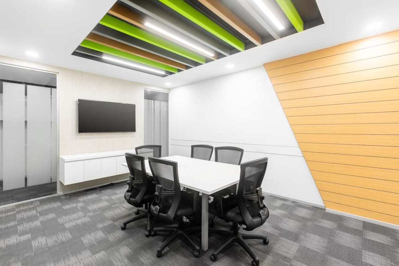 Modern coworking space with sleek design, vibrant ceiling, and comfortable seating on Krishna Rajendra Road.