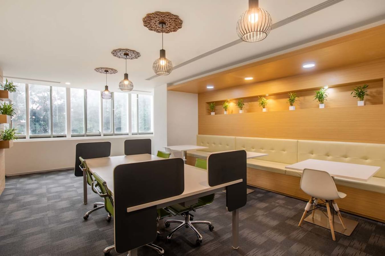 Bright coworking space with modern furnishings, natural light, and greenery accents.