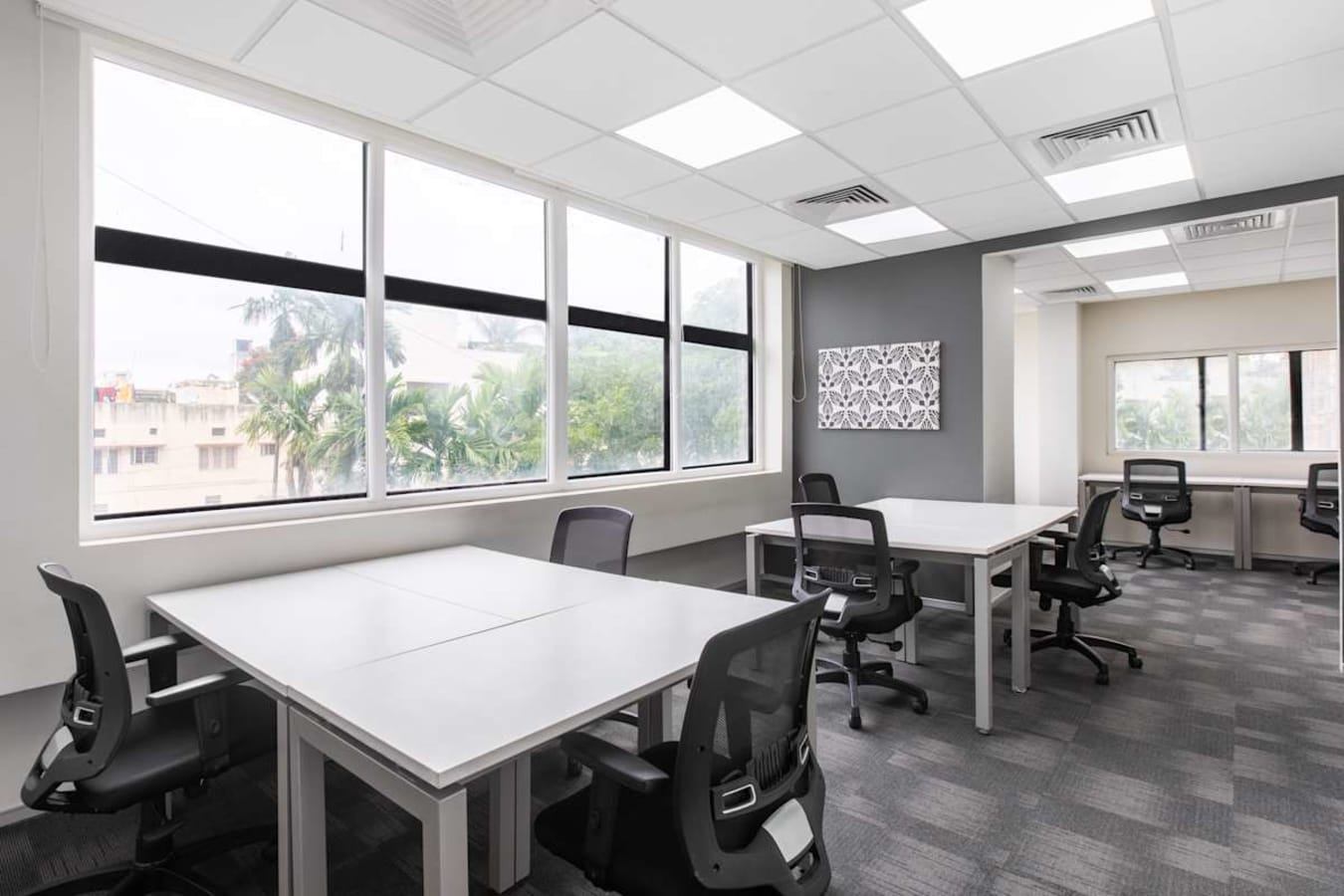Bright coworking space with modern workstations, ergonomic chairs, and natural light. Ideal for productivity.