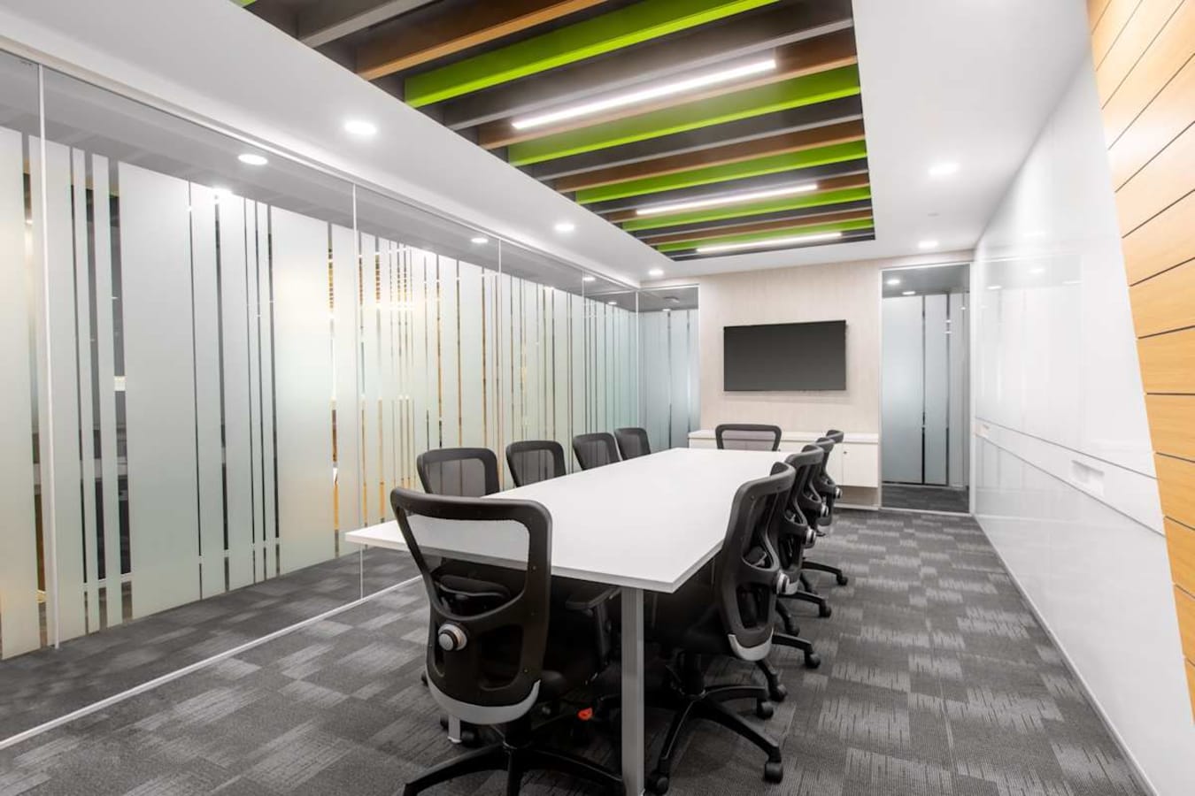 Sleek conference room with modern seating and vibrant ceiling accents. Ideal for collaborative meetings.