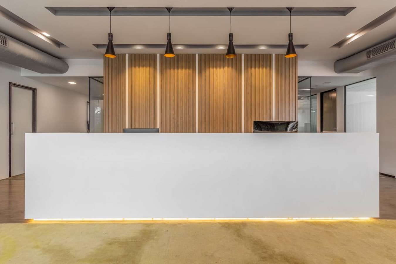 Sleek reception area with modern lighting and wood panel accents in a flexible workspace.