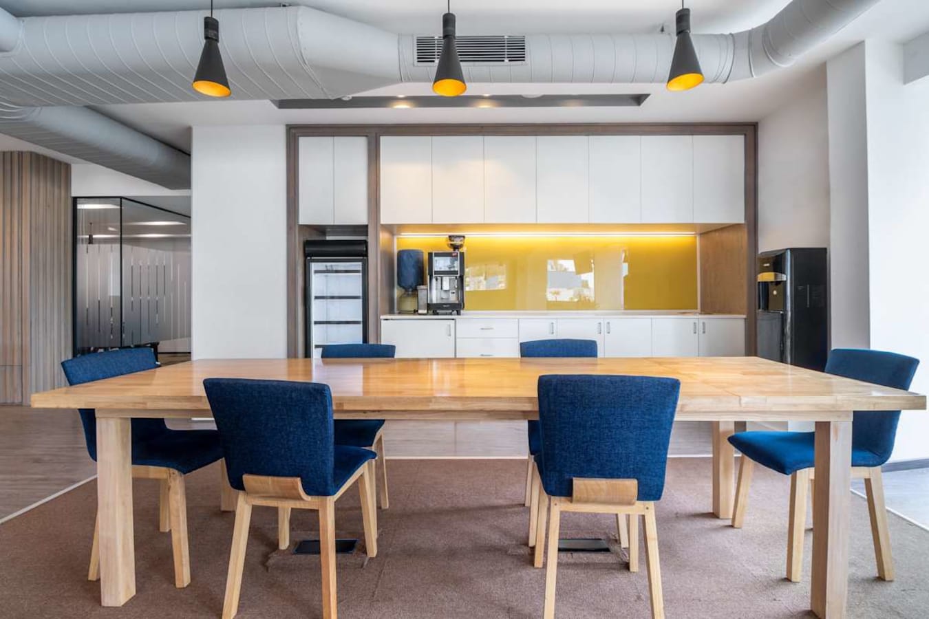 Modern coworking space with a stylish kitchen and ample seating on Doctor Rajkumar Road.