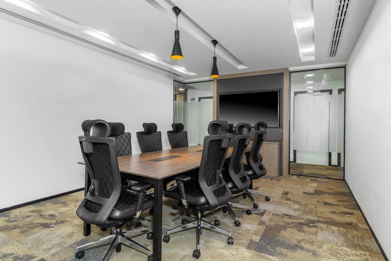 Sleek meeting room with ergonomic chairs and modern tech, ideal for dynamic team discussions.