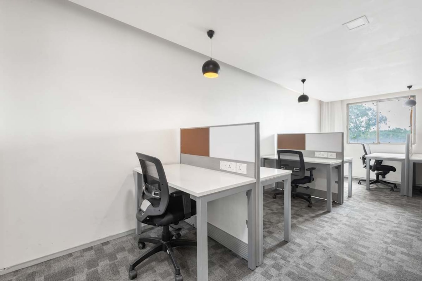 Bright coworking area with ergonomic chairs, modern desks, and ample natural light.
