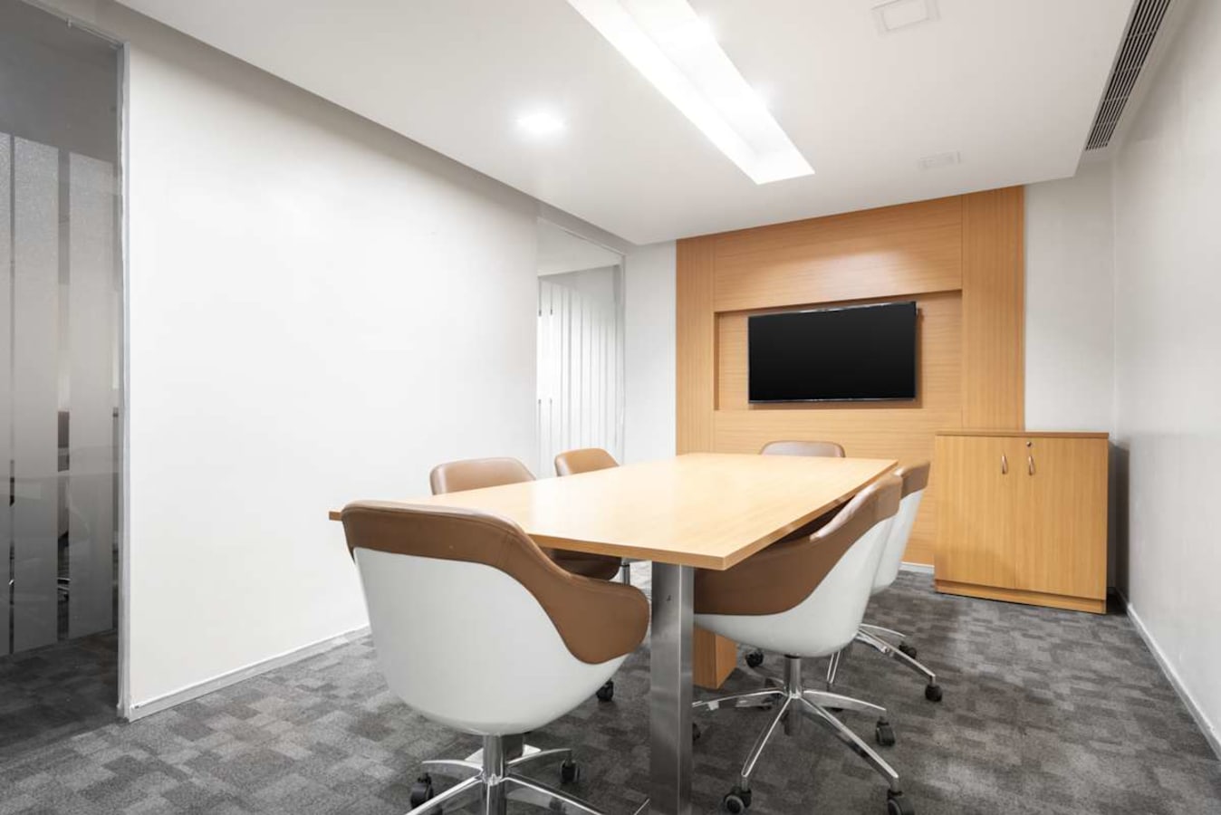 Sleek meeting room with modern chairs, wood accents, and bright lighting for efficient collaboration.