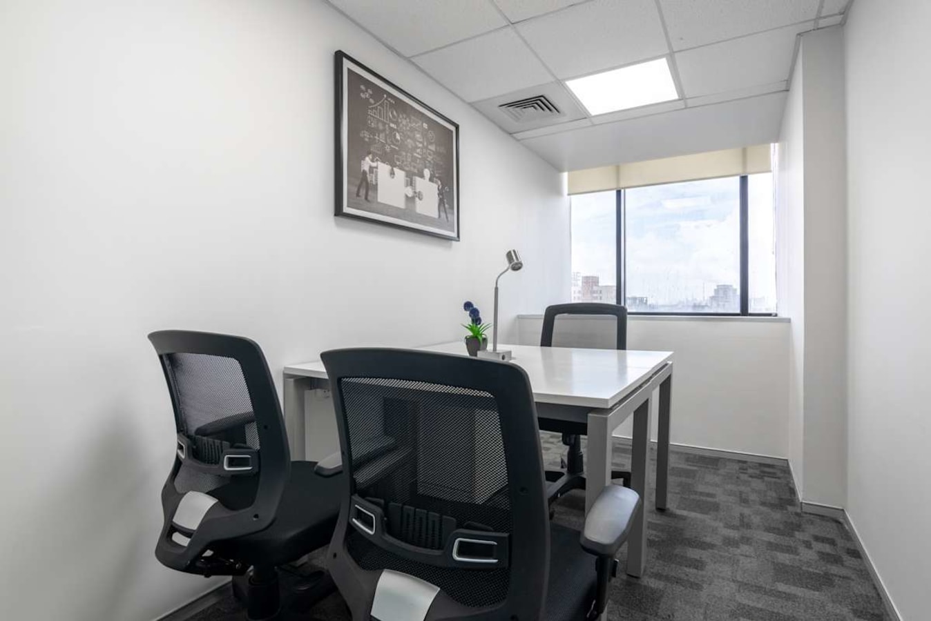 Modern private office with ergonomic chairs, ample natural light, and a sleek design in Sion.