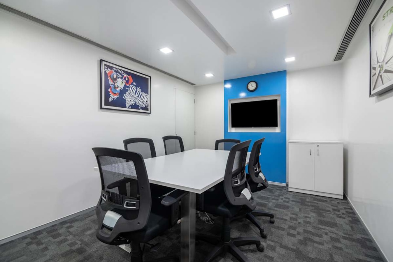 Modern meeting room in Sion-Trombay office, featuring sleek furniture and ample lighting.