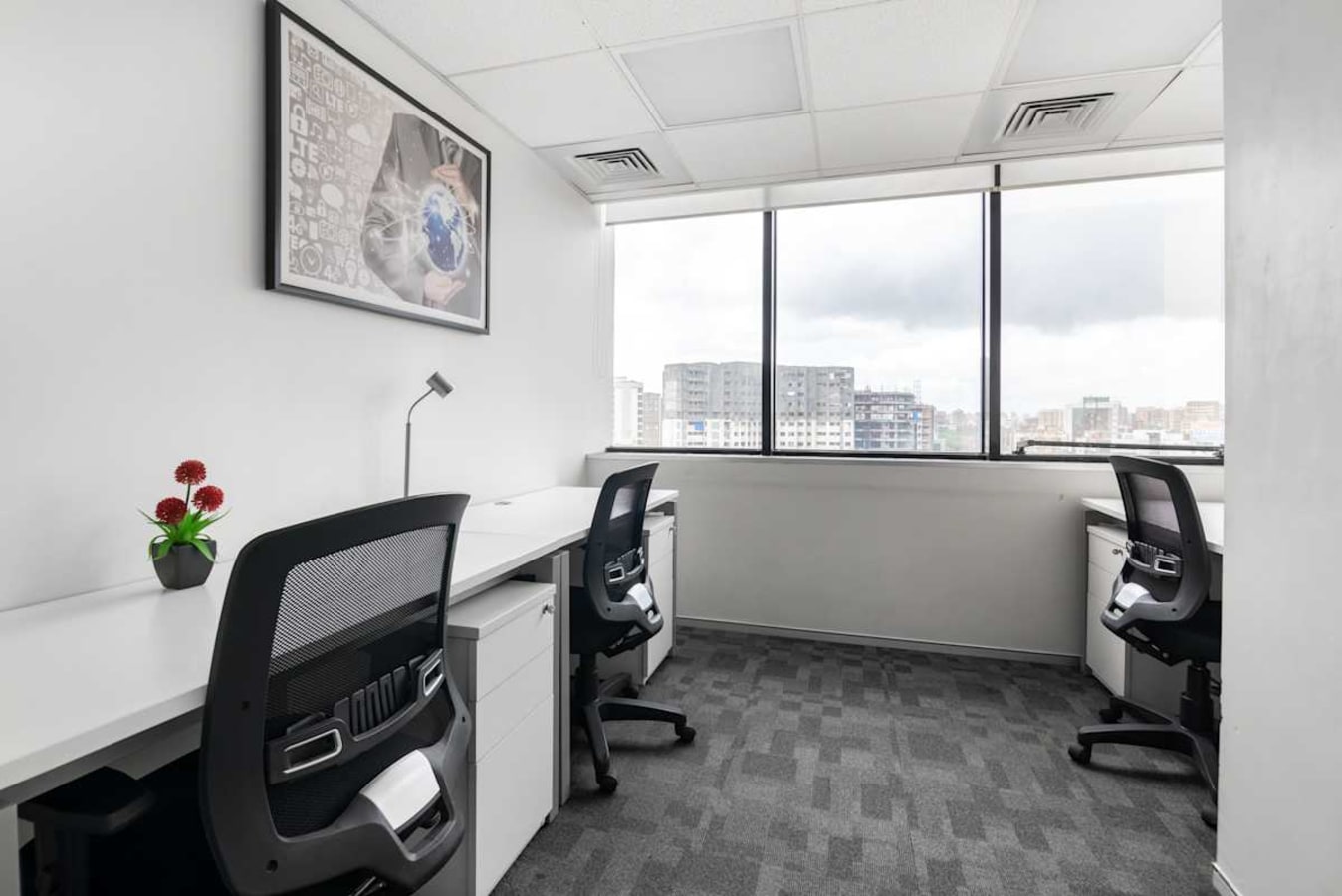 Modern coworking space with bright lighting and ergonomic seating, overlooking an urban skyline.