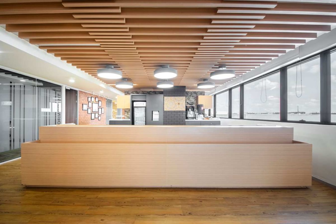 Modern coworking space with ample natural light, sleek wooden accents, and open layout.
