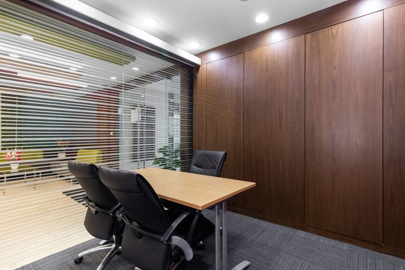 Modern coworking space with sleek wooden paneling and comfortable seating in Karnataka.