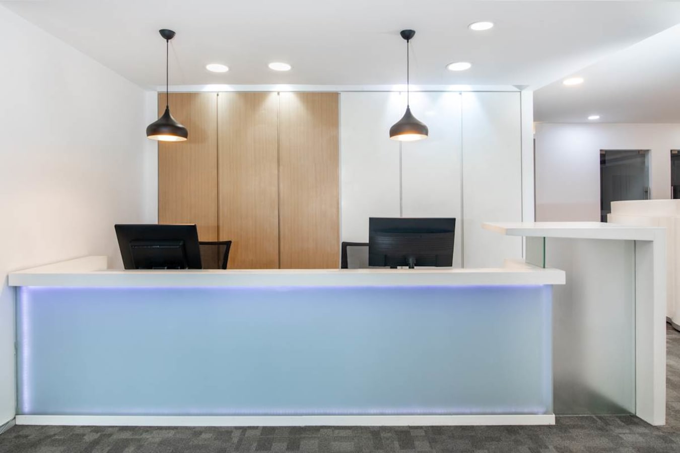 Modern reception area with sleek design, warm lighting, and ample workspace. Perfect for welcoming clients.