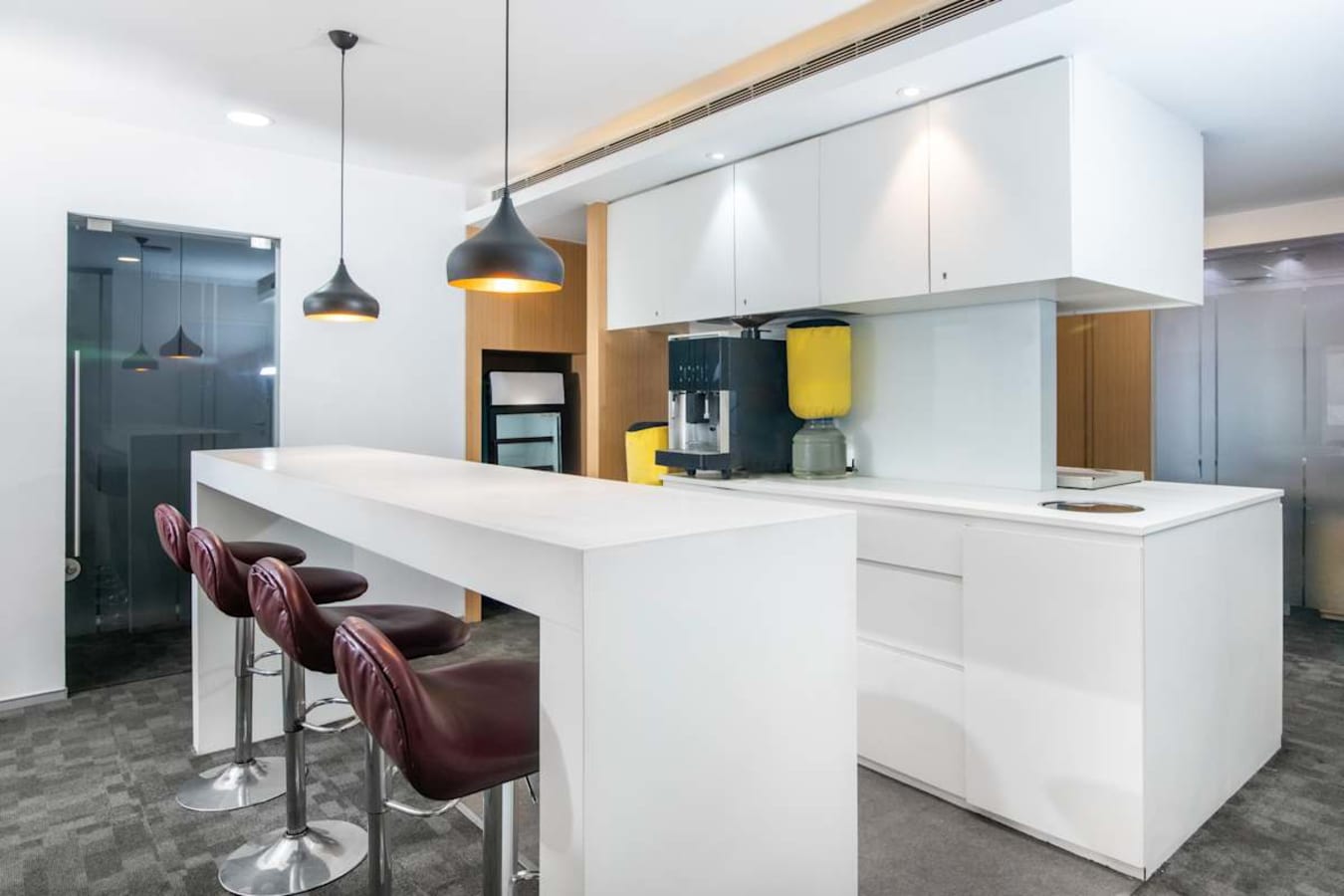 Modern coworking kitchen with sleek white counters and stylish bar seating on Camac Street.