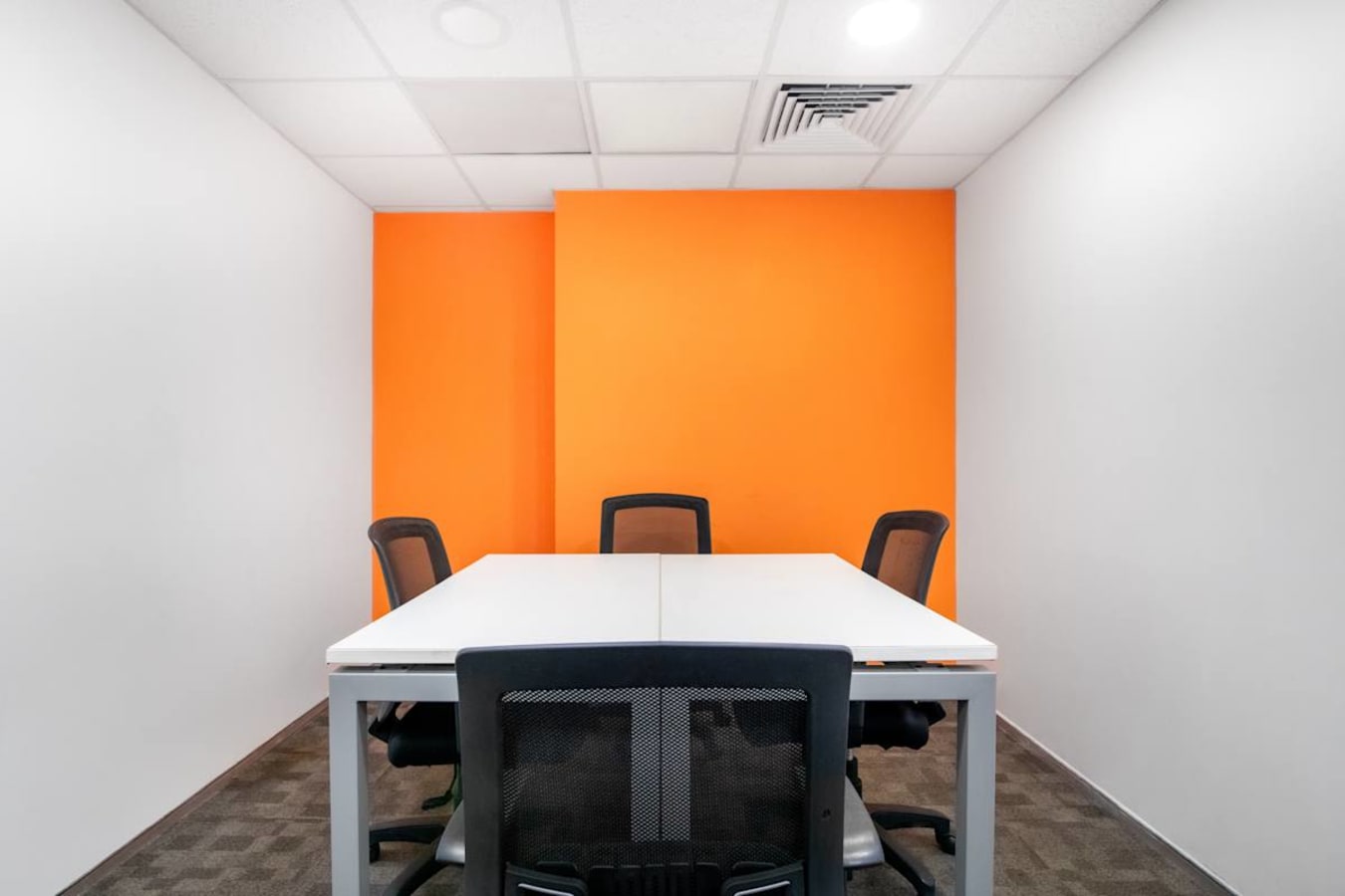 Bright, modern meeting room with vibrant accent wall and ergonomic seating in Camac Street.