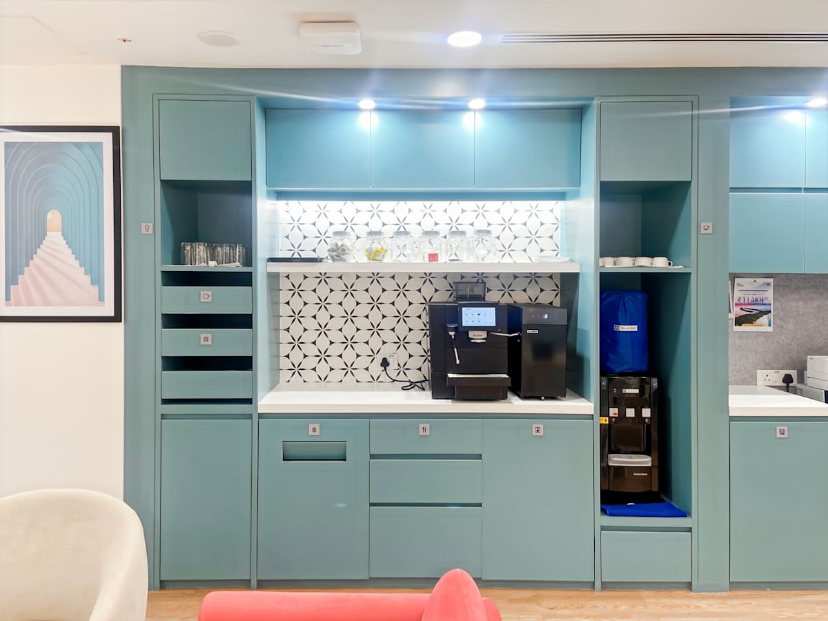 Sleek kitchen area with modern cabinetry and coffee amenities in Karnataka coworking space.