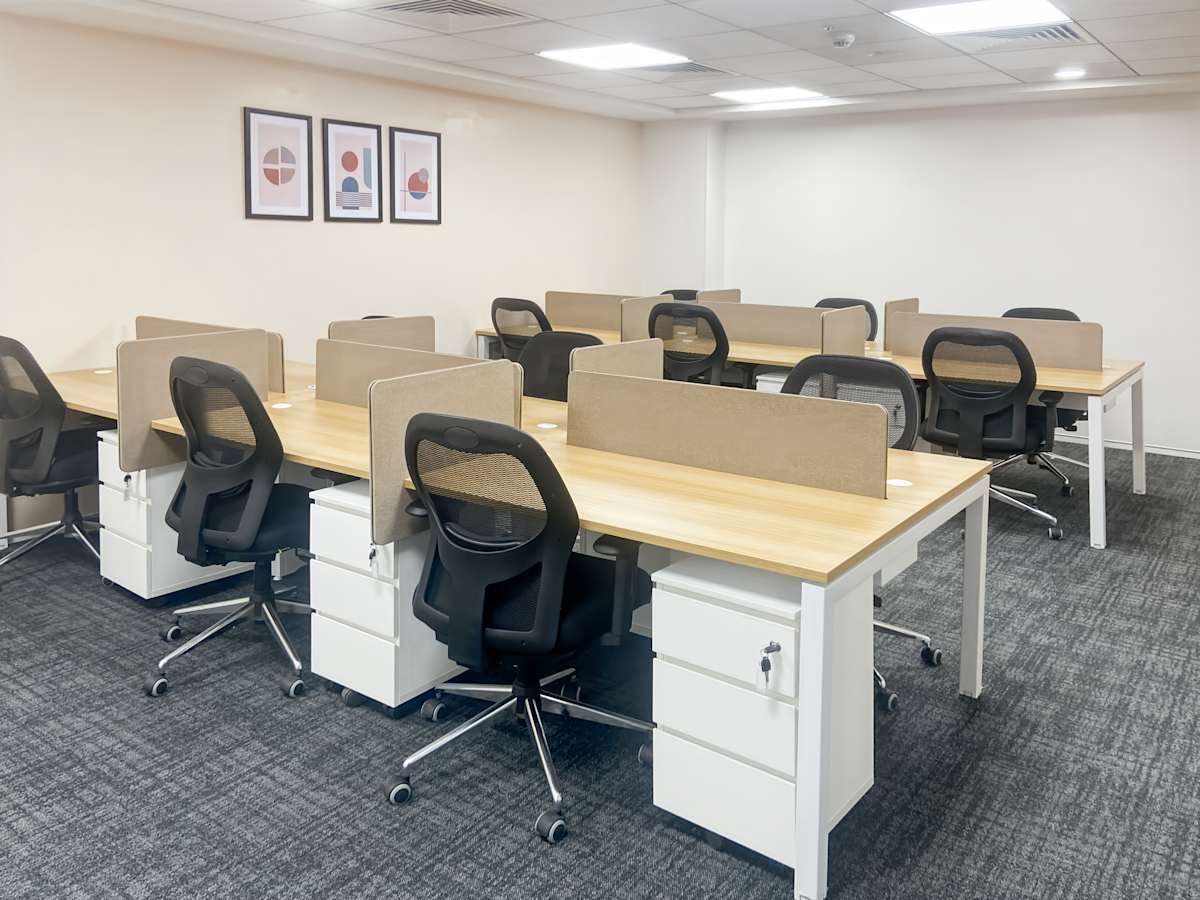 Modern coworking space with ergonomic chairs, ample desks, and bright lighting. Located in Karnataka.