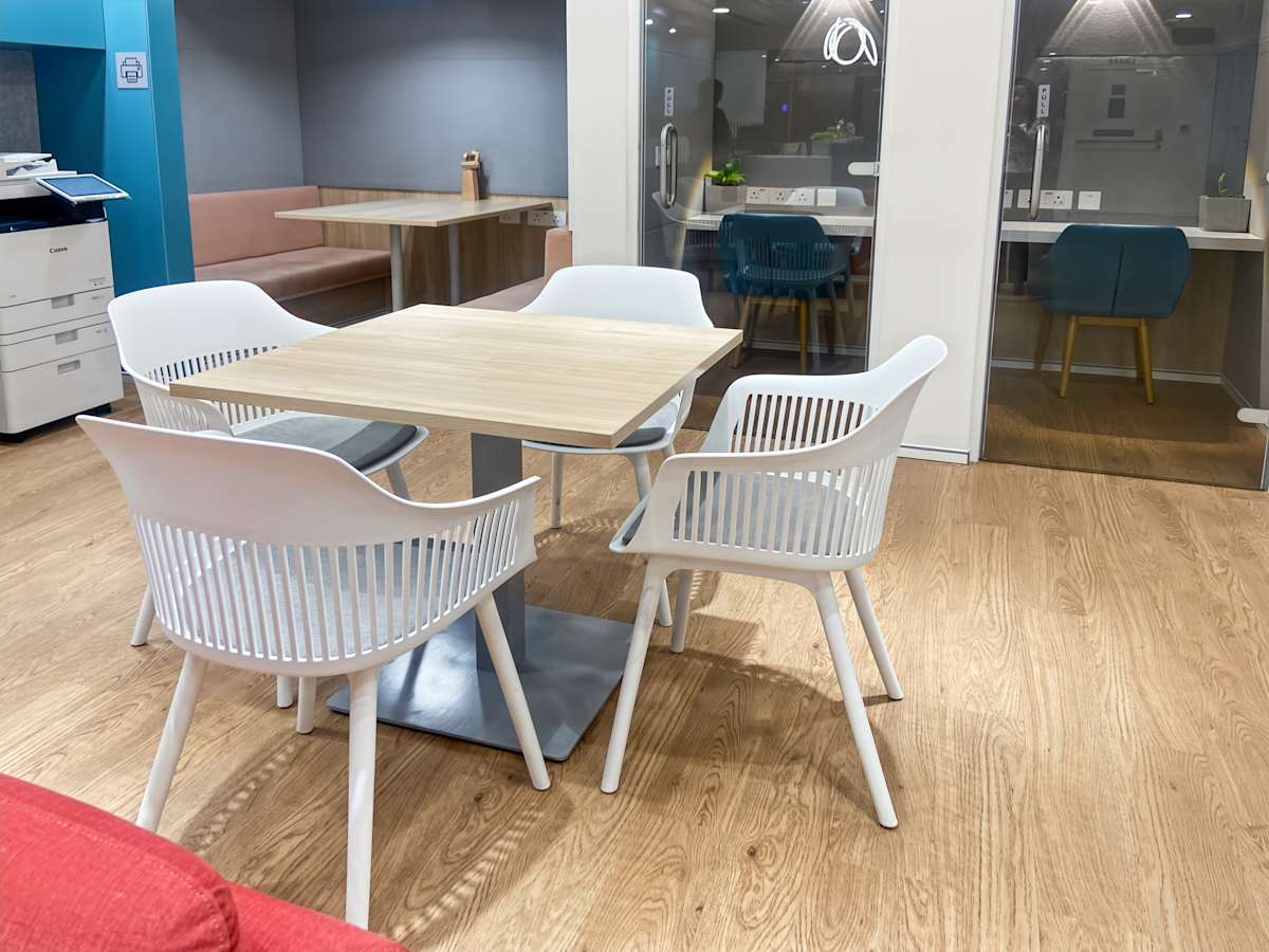 Modern coworking area with sleek furniture and wood flooring, perfect for collaboration.