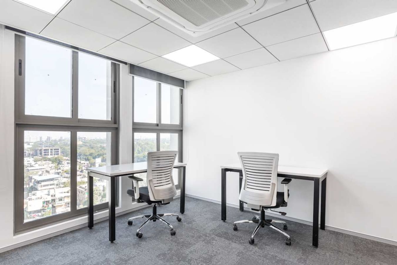 Bright coworking space with modern desks, ergonomic chairs, and large windows for natural light.