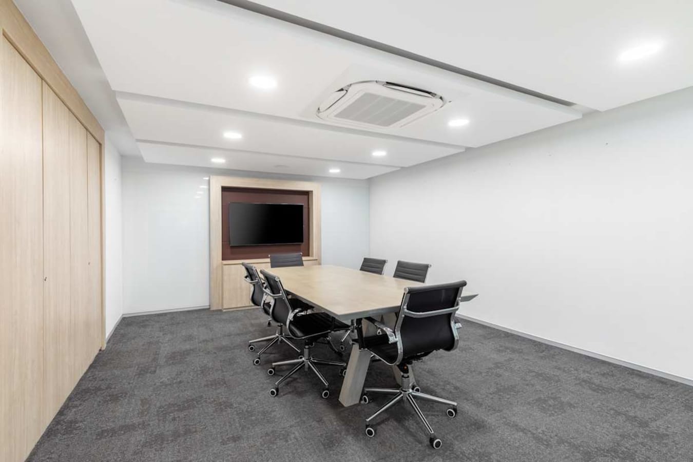 Modern meeting room with sleek chairs, large screen, and ample lighting on Judges Bunglow Road.