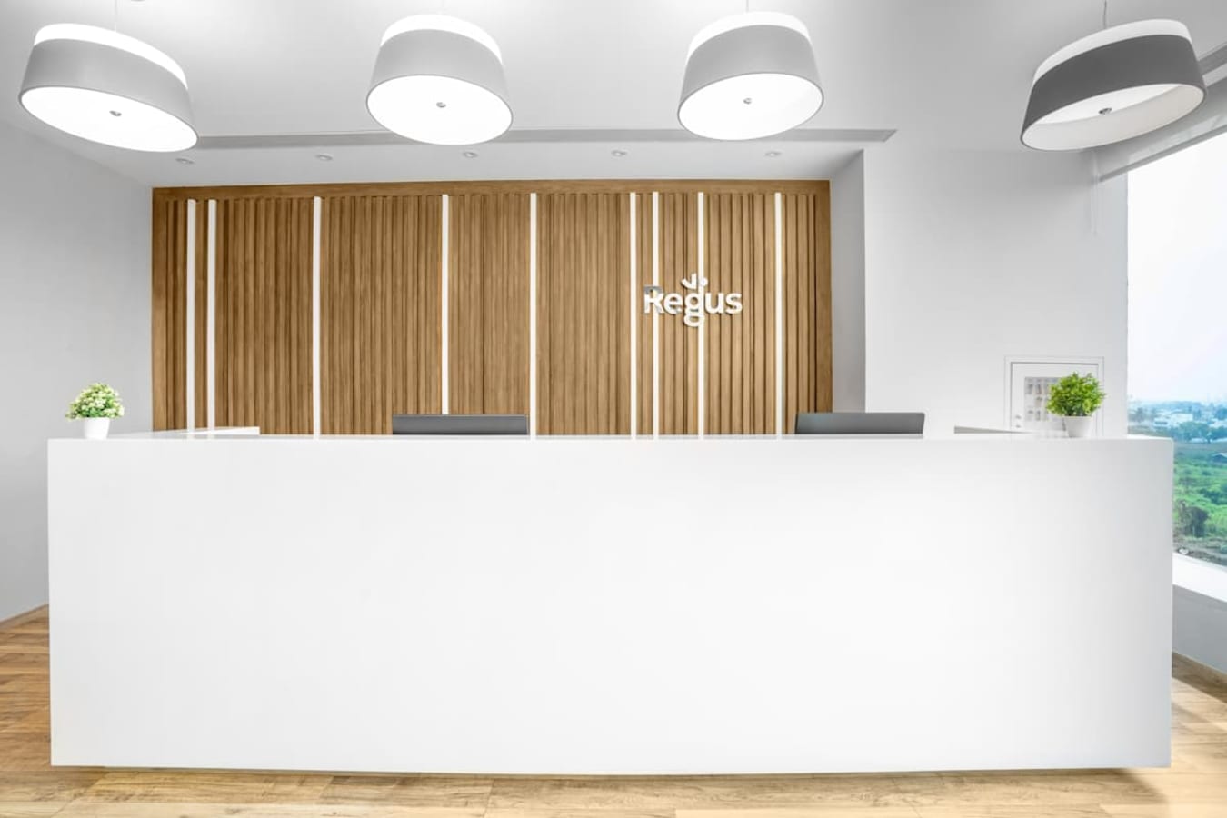Sleek reception area with modern design and ample natural light in a coworking space.