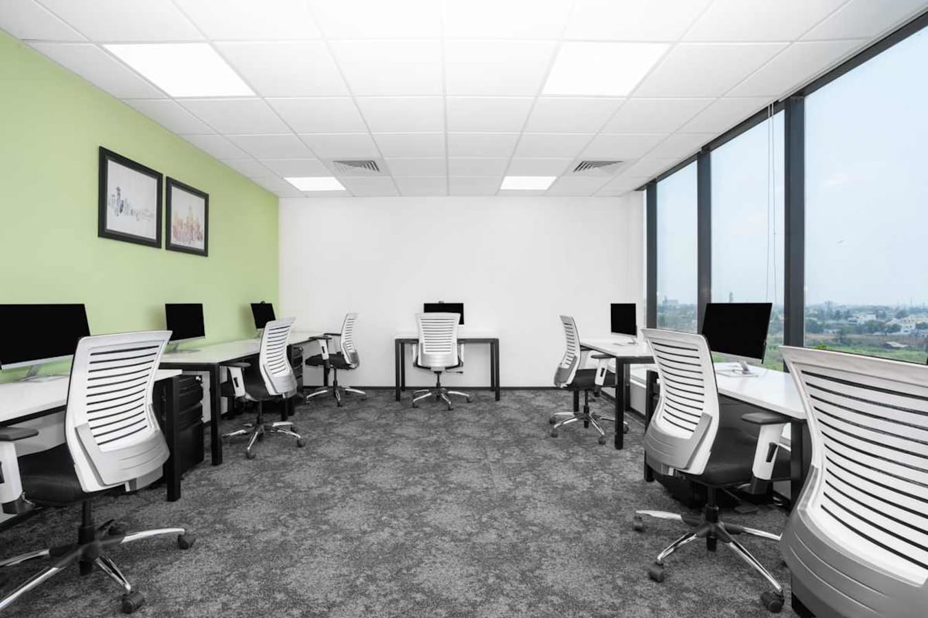 Bright and airy coworking space with modern desks, ergonomic chairs, and a scenic view.