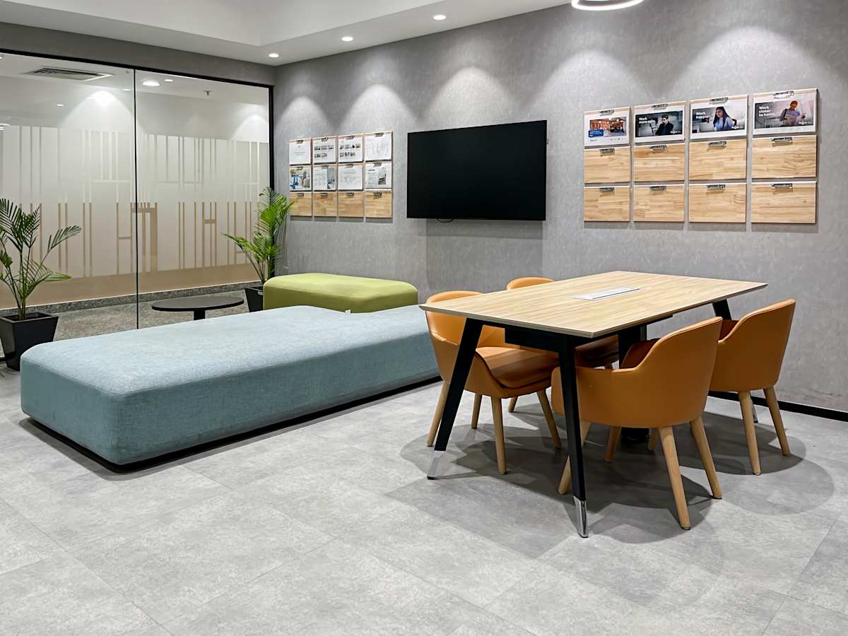 Modern Gurugram coworking area with sleek seating, flat-screen TV, and glass partition. Ideal for collaboration.