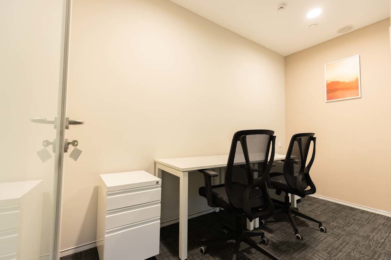 Modern coworking space with sleek desks, ergonomic chairs, and ample natural light. Ideal for productivity.