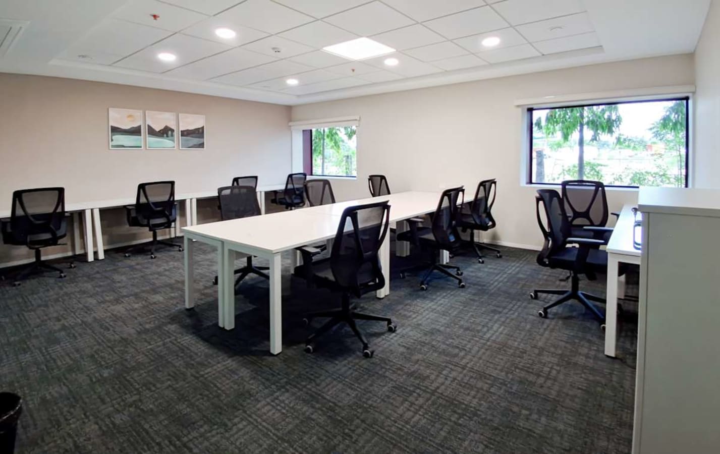 Modern coworking space with ergonomic chairs, ample natural light, and collaborative desks.
