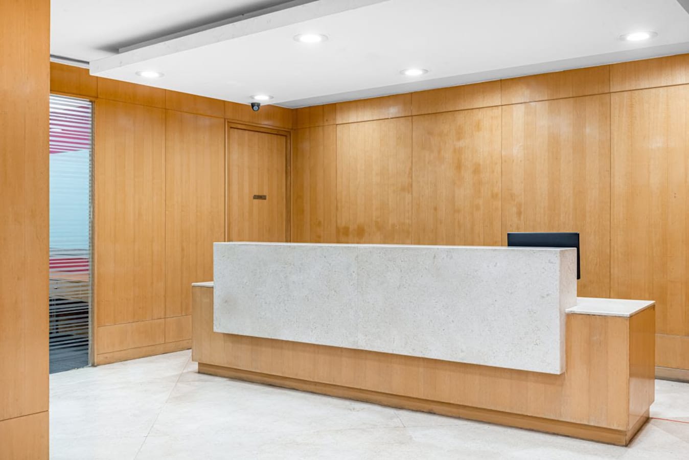 Modern reception area with sleek wood paneling and ambient lighting, ideal for a welcoming workspace.