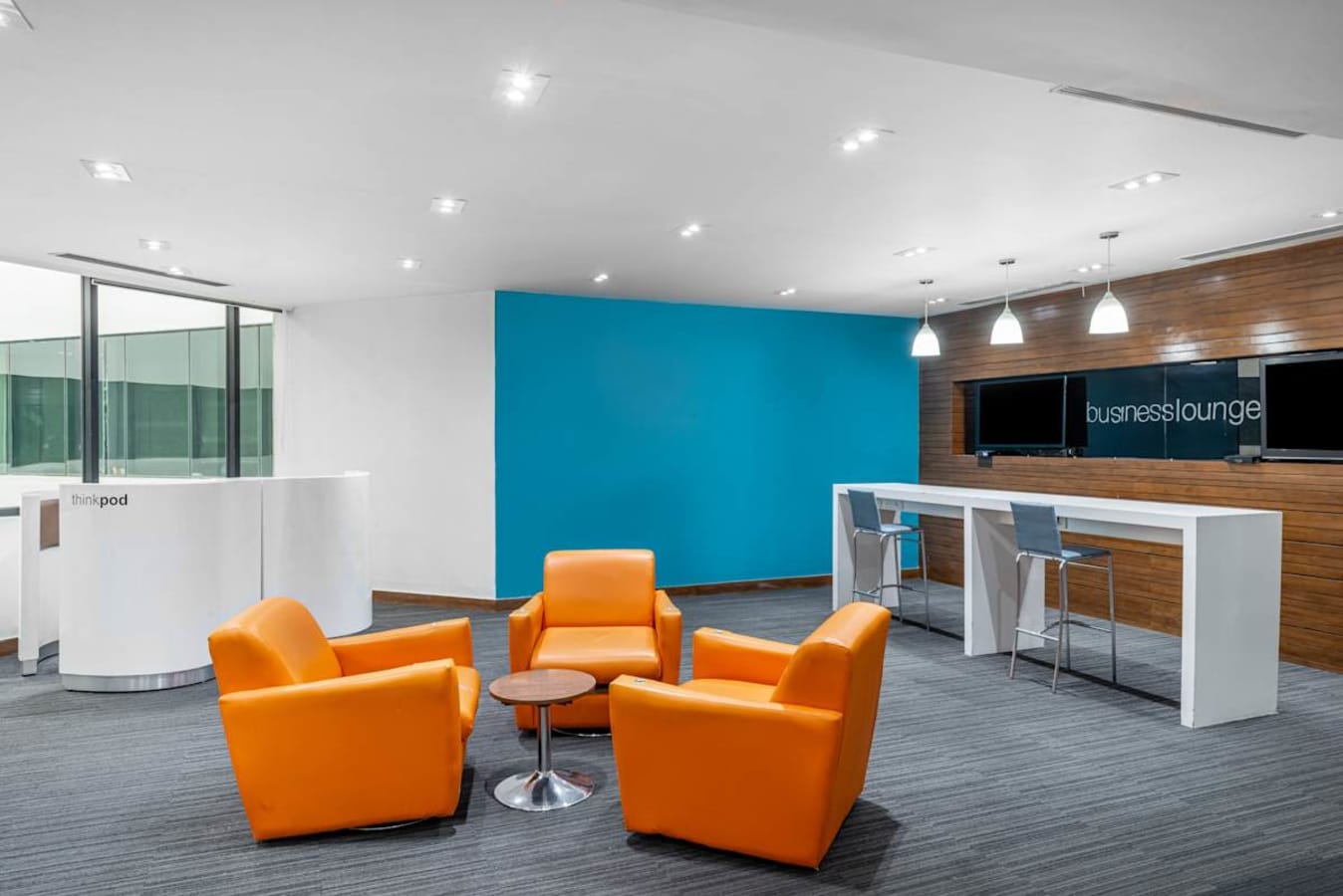 Modern coworking space with vibrant seating, sleek desks, and bright ambient lighting.