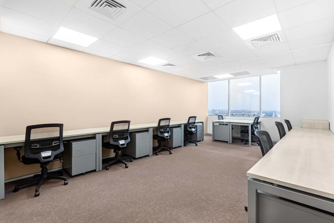 Spacious coworking area with individual desks and ergonomic chairs, ideal for productive work.