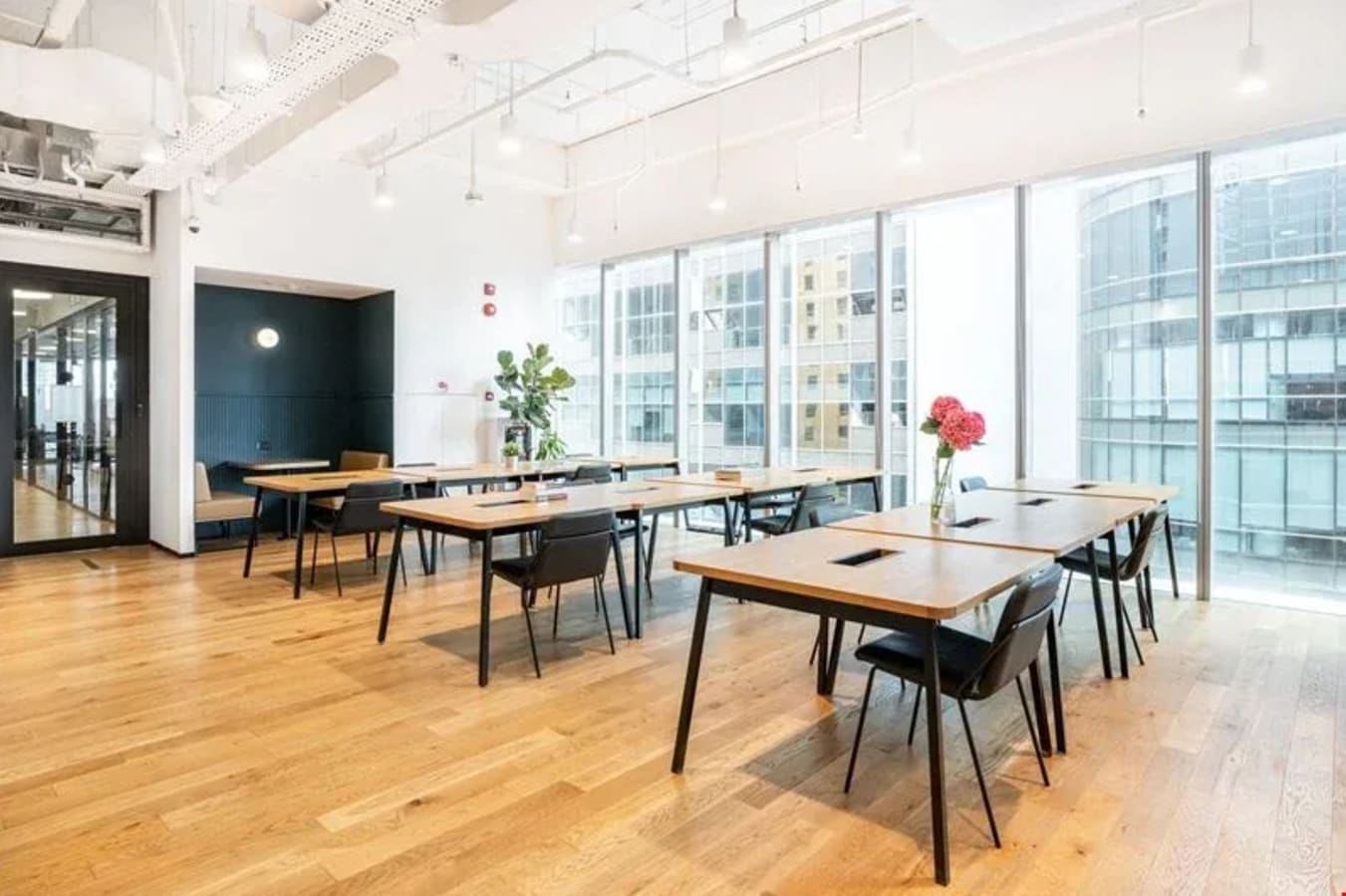 Spacious coworking area with sleek desks, modern lighting, and city views on Robinson Road.