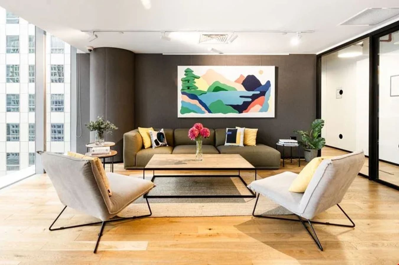 Bright coworking space with modern art, plush seating, and ample natural light on Robinson Road.