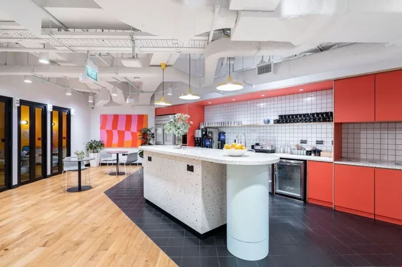 Contemporary coworking kitchen with vibrant accents and ample seating in Robinson Road.