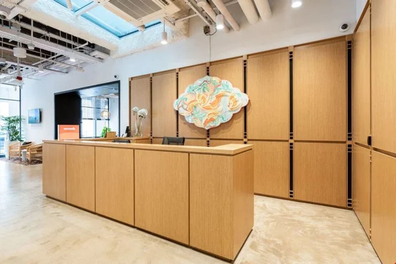 Modern coworking reception with sleek wooden design and ample natural light in Cross Street, Singapore.