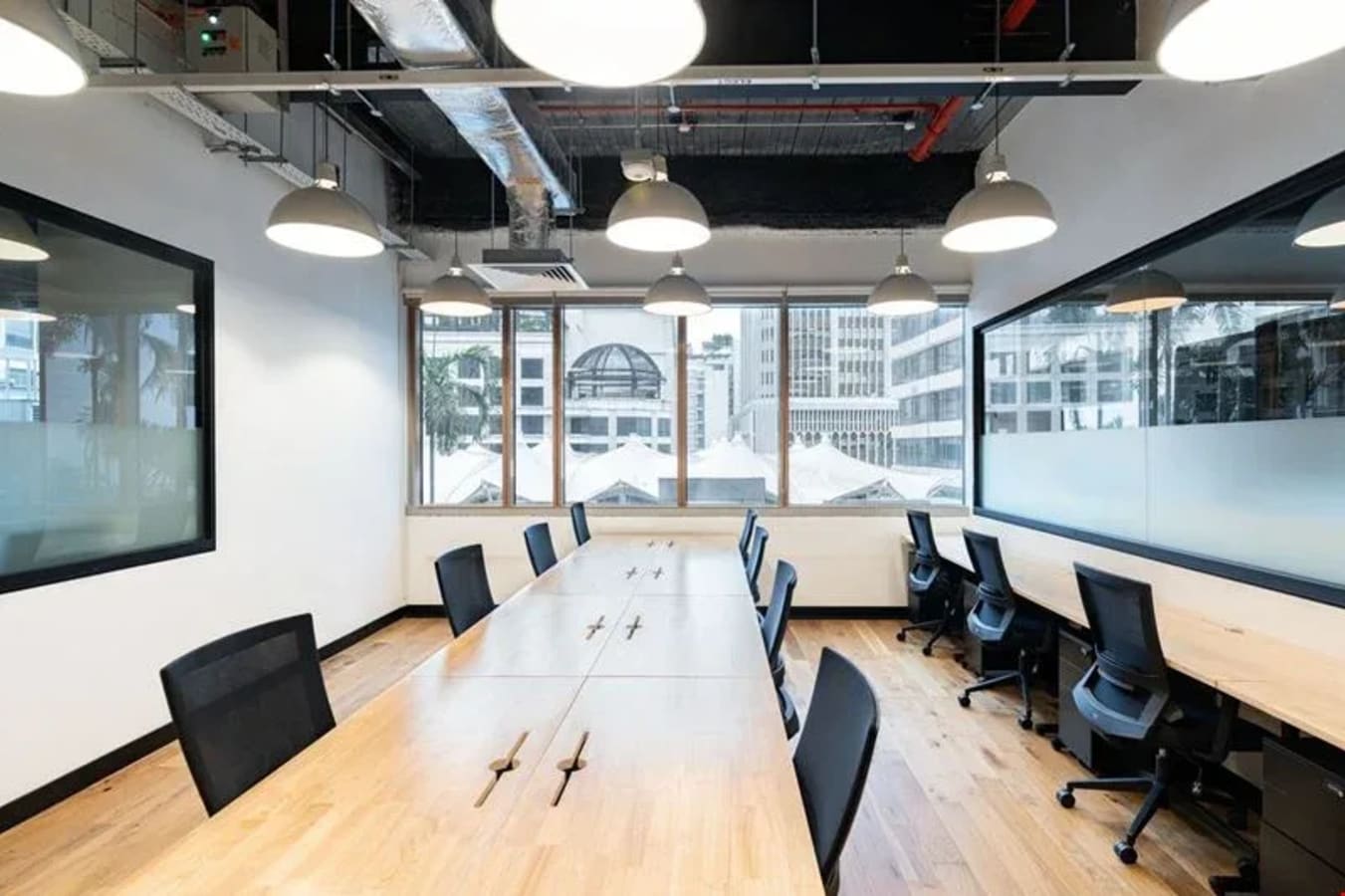Bright coworking space with modern furnishings, large windows, and ample natural light on North Bridge Road.
