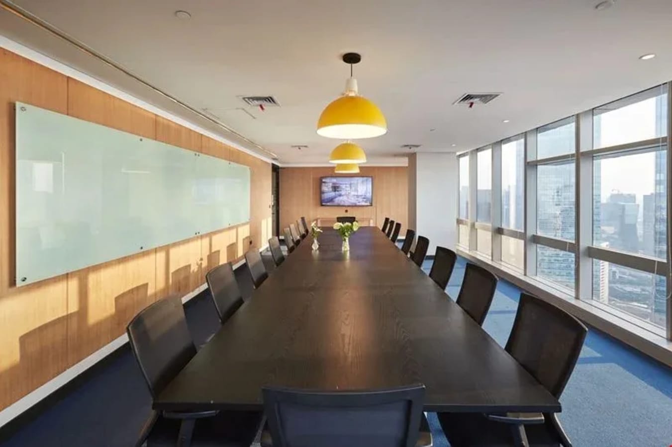 Spacious meeting room with city views, modern furnishings, and ample natural light.