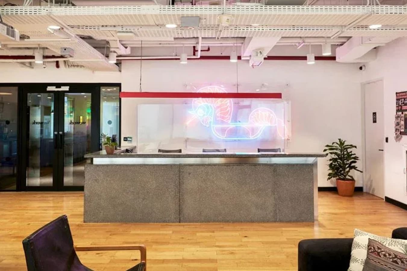Modern coworking space with vibrant lighting and sleek front desk in Jakarta's business hub.