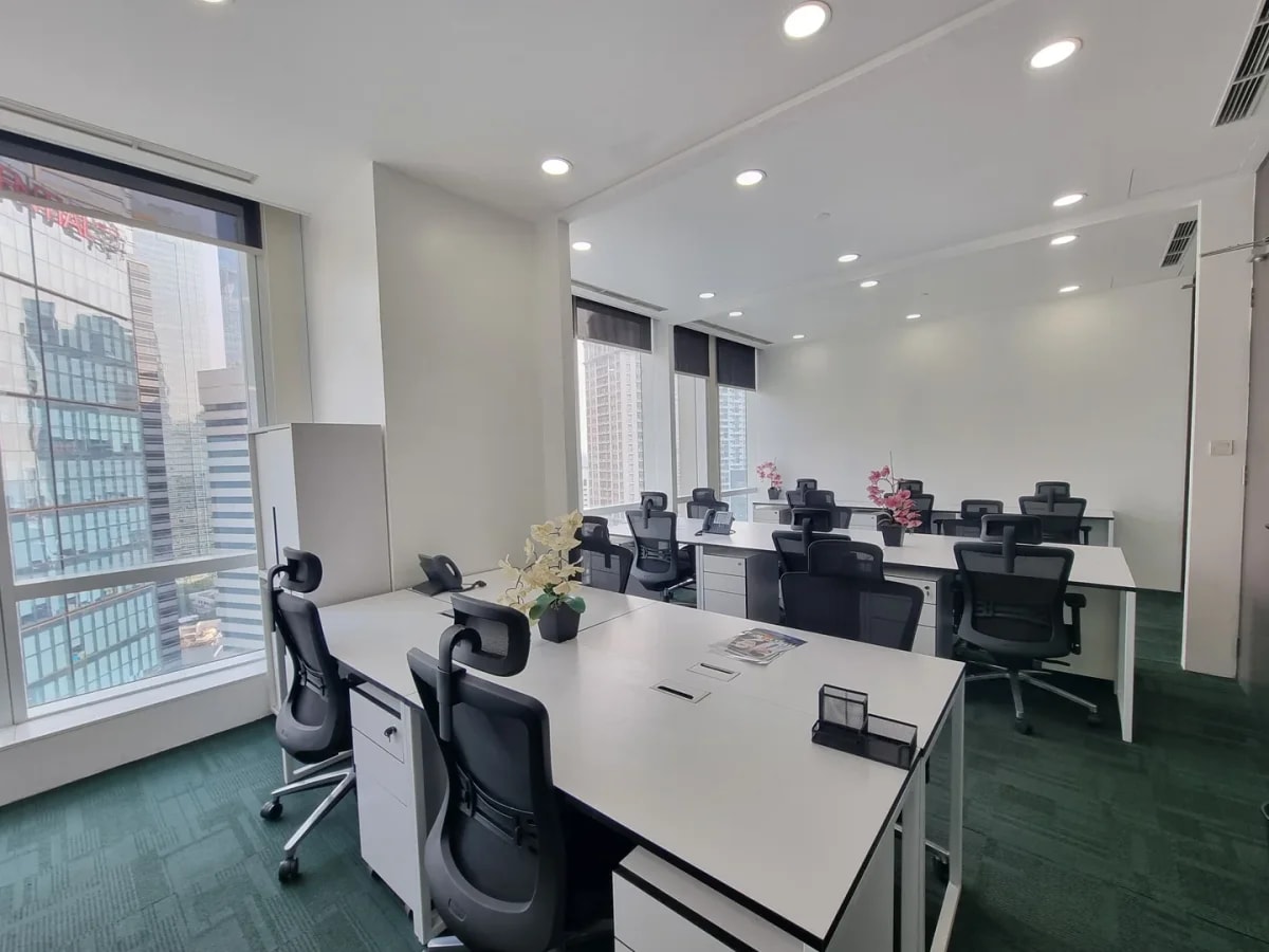 Modern coworking space with city views, ergonomic chairs, and ample natural light.
