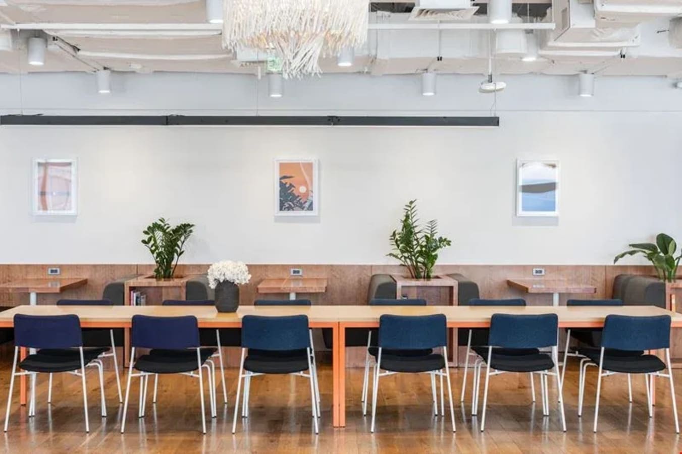 Modern coworking space on Ayala Ave. features communal tables, vibrant chairs, and greenery.