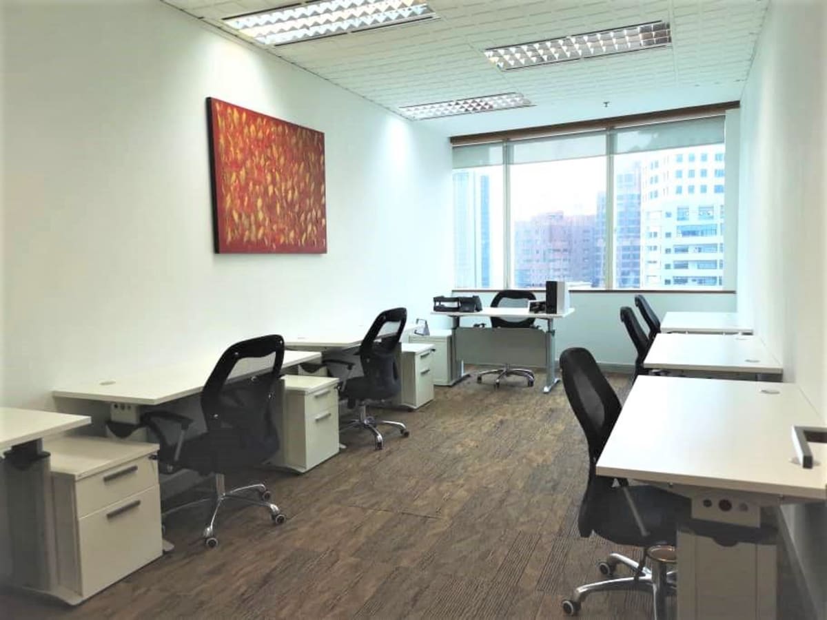 Bright, spacious coworking area with modern desks, ergonomic chairs, and city views.