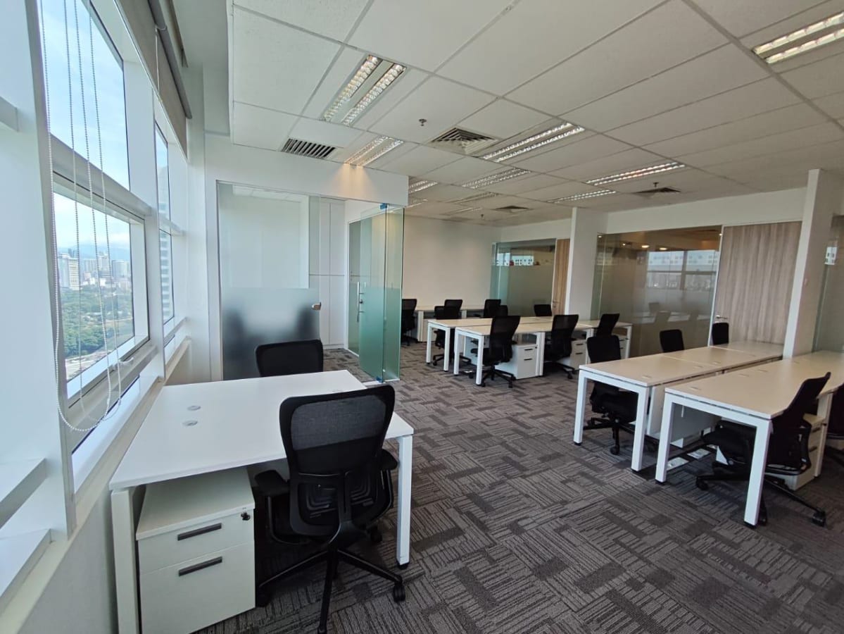 Modern coworking space with abundant natural light and versatile workstations in Jalan Stesen.