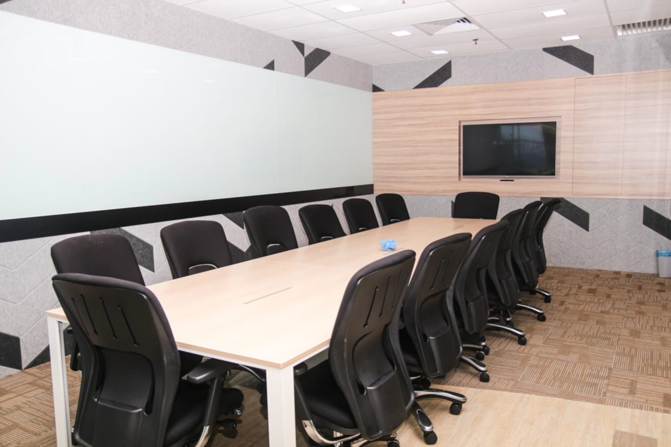 Modern meeting room with ample seating, large conference table, and sleek design elements.