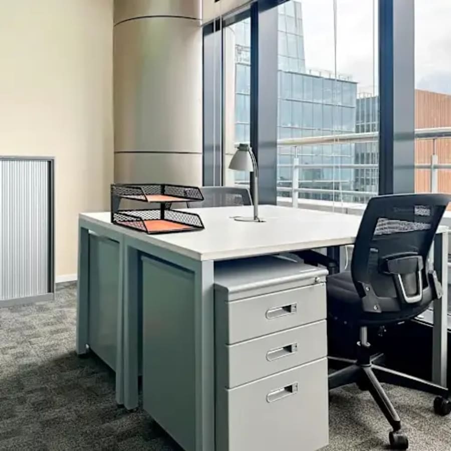 Modern coworking desk with city views, ample natural light, and sleek furnishings in Fort Bonifacio.