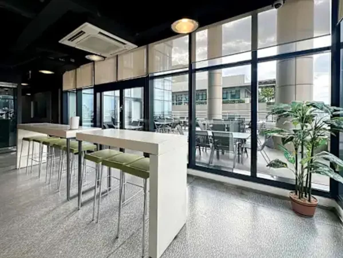 Bright, modern coworking space in Taguig with floor-to-ceiling windows and contemporary seating.
