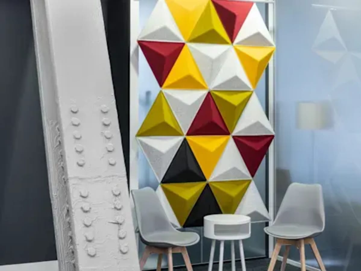 Colorful, modern meeting area with geometric wall art and sleek seating in Taguig coworking space.